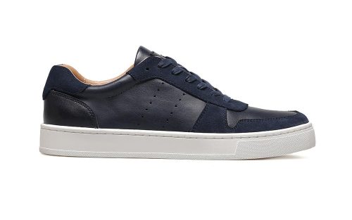 Navy leather low-top sneaker with white sole, side view, shown on a plain white background.