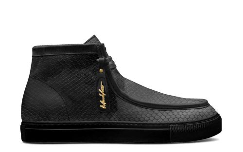 Side view of Amalfi leather loafers in black with textured finish and gold tag, displayed on a white background.